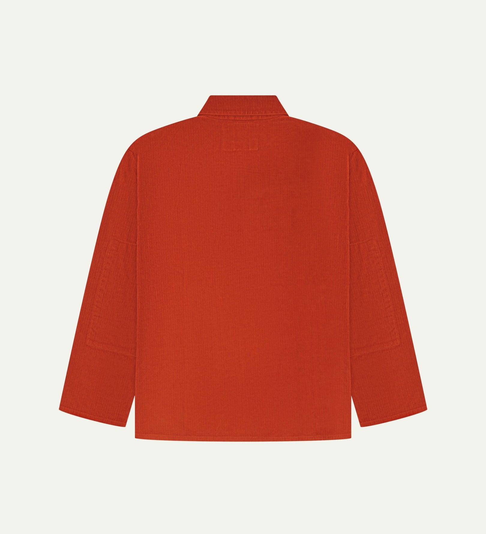 Back view of rust-red, buttoned corduroy overshirt with view of reinforced elbow area and boxy silhouette.