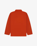 Back view of rust-red, buttoned organic cotton overshirt with view of reinforced elbow area and boxy silhouette.