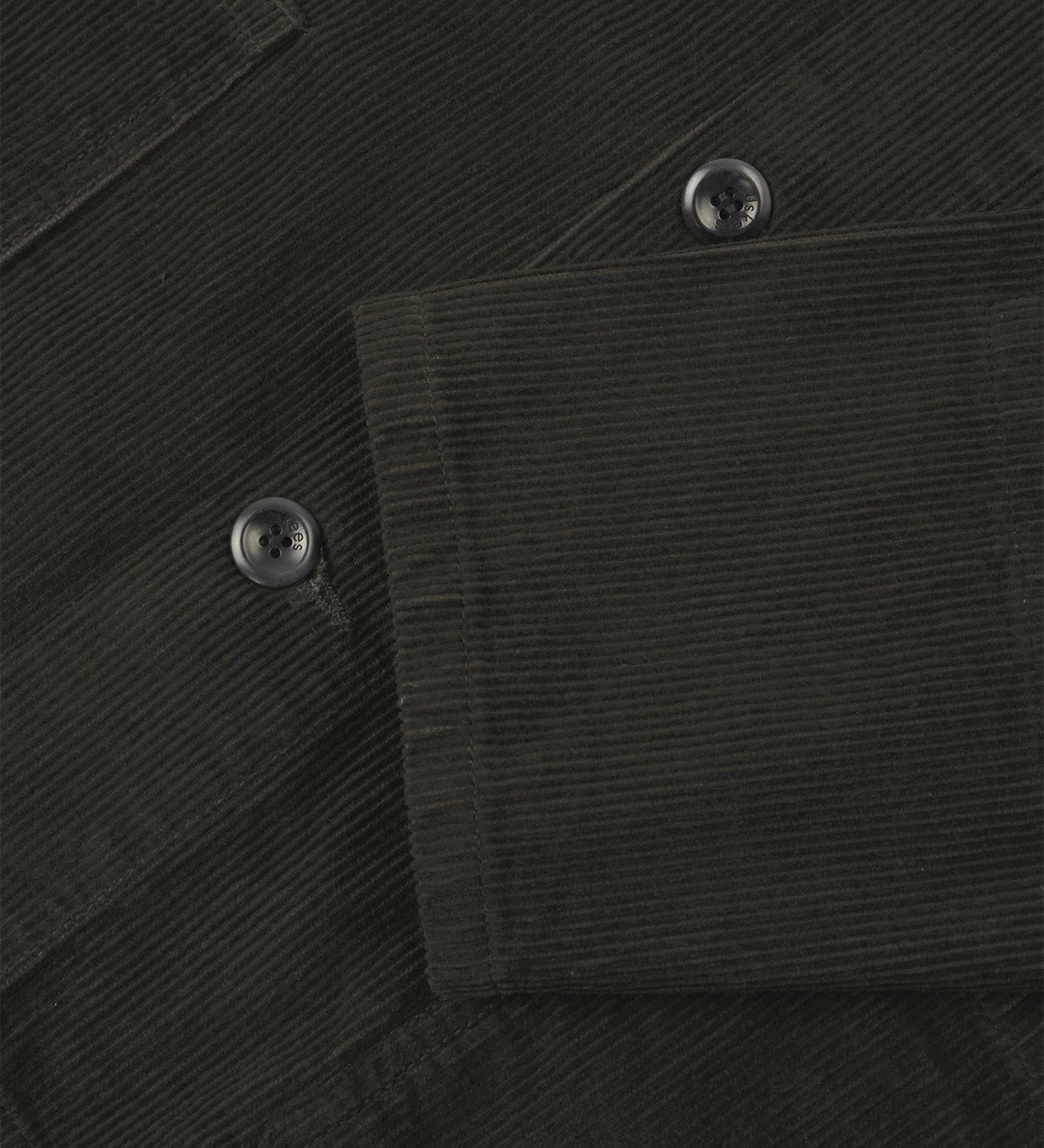 Closer view of mid section of green-brown (seaweed), buttoned corduroy overshirt from Uskees. Focus on cuff, pockets, corozo buttons and corduroy texture.