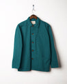 Super green coloured, buttoned organic cotton overshirt from Uskees presented on hanger. Clear view of breast and hip pocket and corozo buttons.