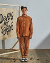 Full-length front view of model wearing fastened #3001, tan corduroy overshirt paired with matching Uskees tan cord pants.