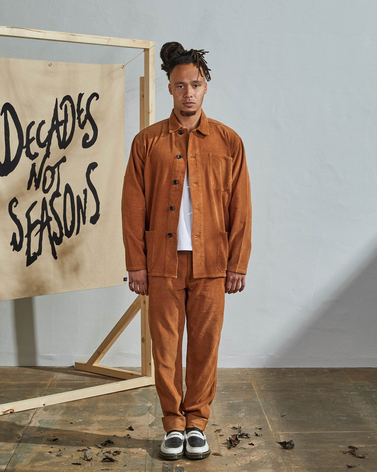 Full-length front view of model wearing unfastened #3001, tan corduroy overshirt paired with matching Uskees tan cord pants.