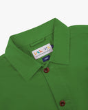 Close-up view of 3001 bright green, buttoned organic cotton overshirt from Uskees showing corozo buttons, branding label, collar and hanging loop.