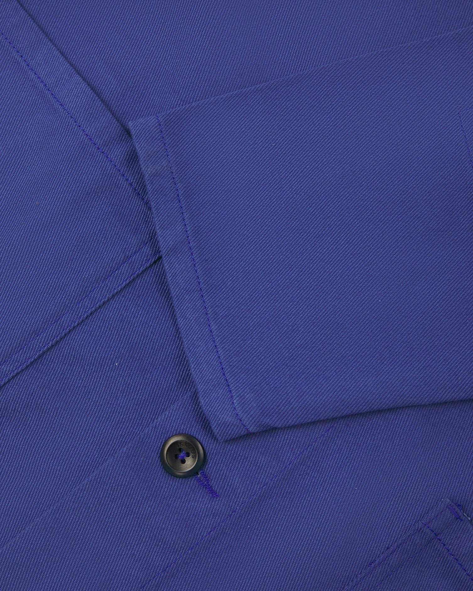View of the mid-section and sleeve of the 3001 Uskees button-down drill overshirt in ultra blue with focus on cuff, placket and hip pocket.