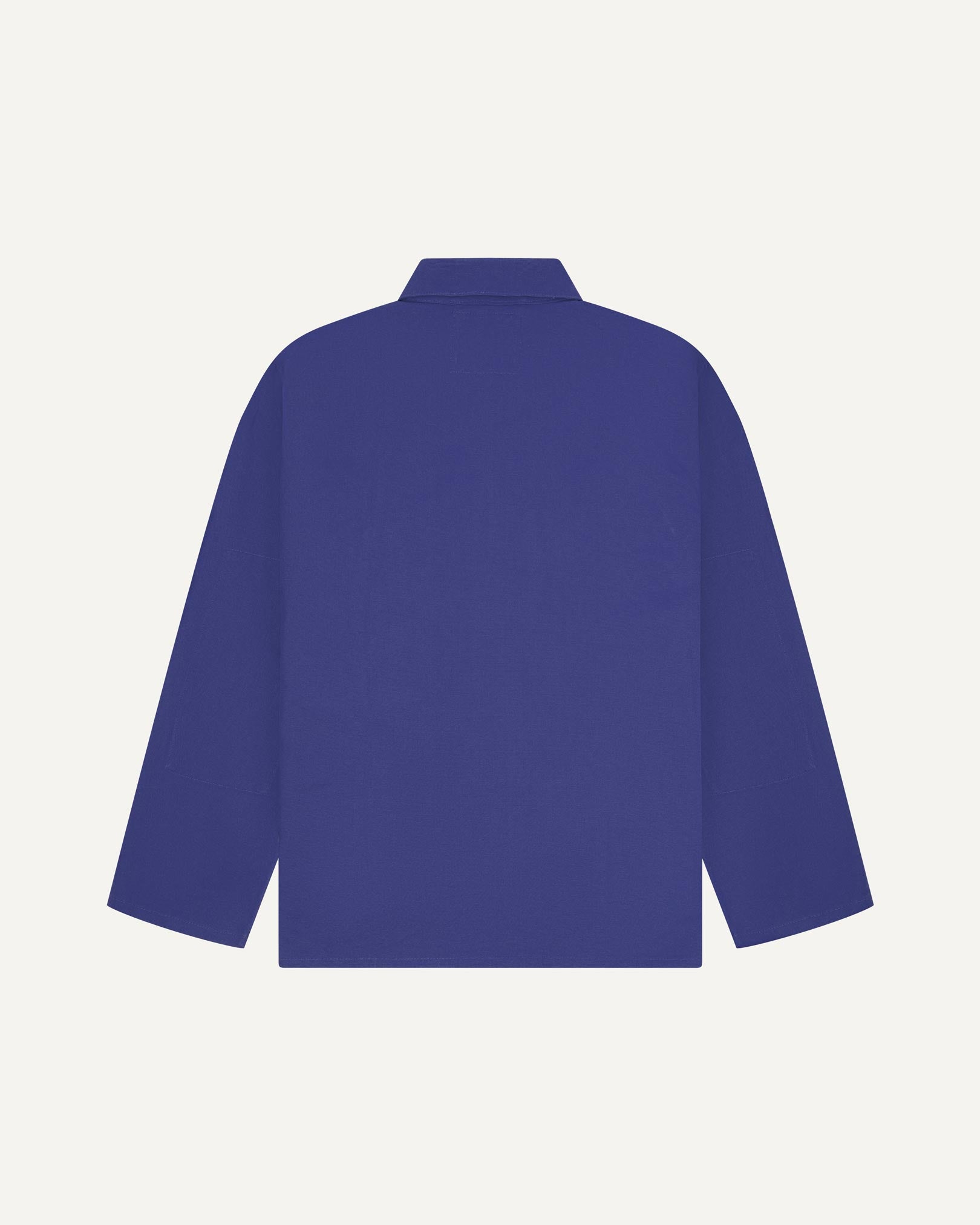 Back view of ultra blue, buttoned organic cotton overshirt with view of reinforced elbow area and boxy silhouette.