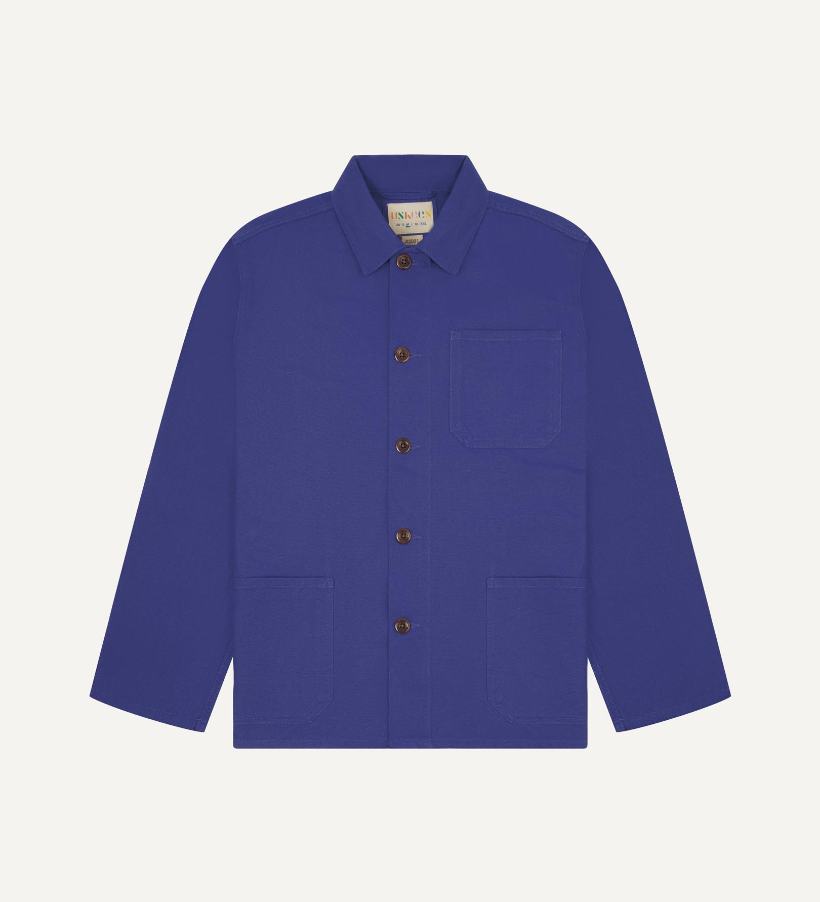 Front flat shot of ultra blue, buttoned organic cotton overshirt. Clear view of chest and hip pockets, corozo buttons and Uskees branding label.