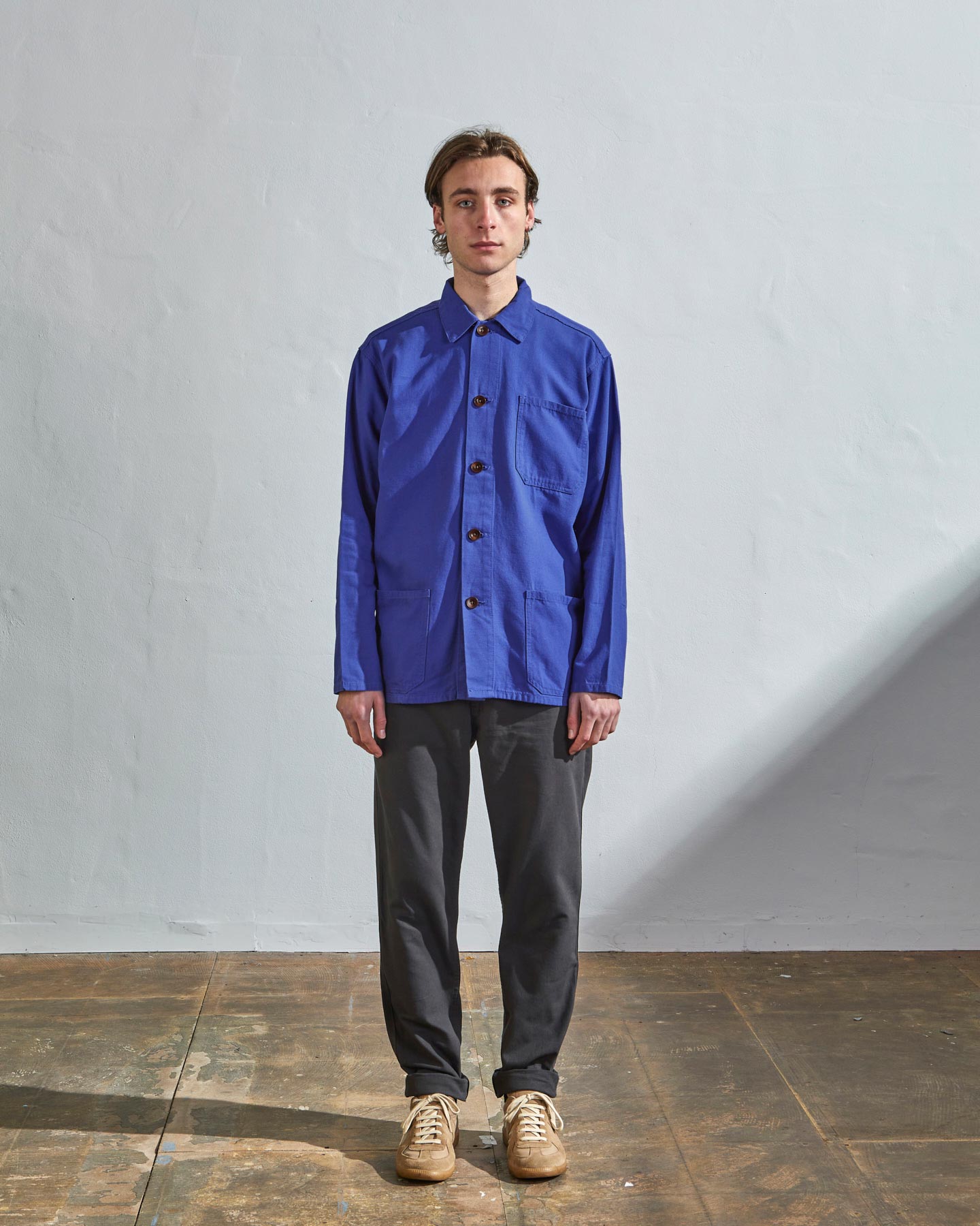 Full-length front view of model wearing 3001, 'ultra-blue' over shirt paired with grey pants.