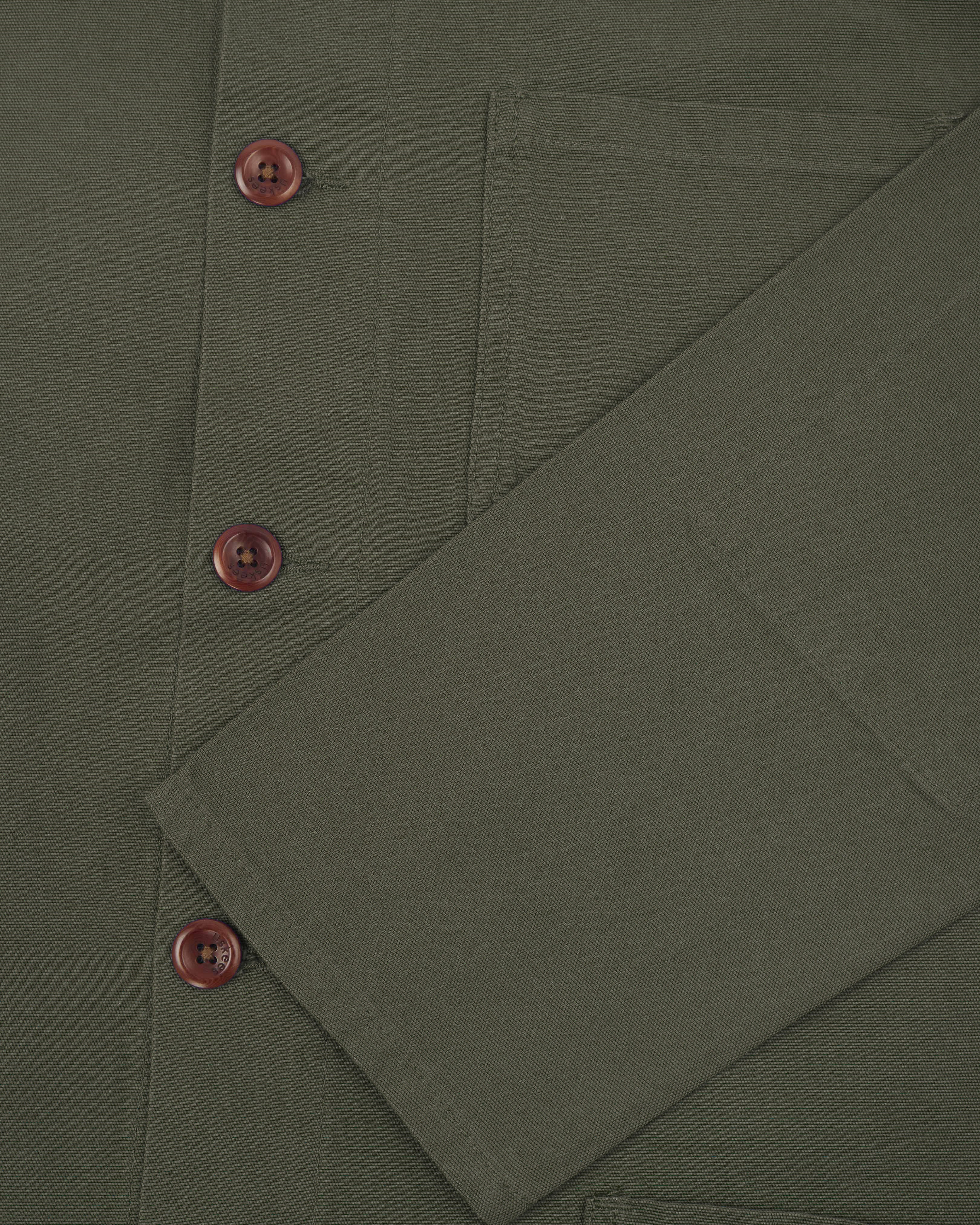 Front close shot of an uskees dull green men's overshirt showing brown corozo buttons and sleeve/cuff detail.
