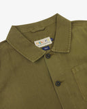 Close-up top-half view of #3001 khaki-green linen blend overshirt. With focus on collar, Uskees brand label and corozo buttons.