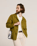 Top-half view modelling 3001 Uskees men's linen blend khaki-green linen blend overshirt. Paired with white Uskees shirt.