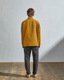 Full-length rear view of model wearing #3001, yellow organic cotton over shirt with reinforced elbows.