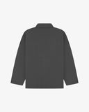 Reverse of charcoal-grey buttoned organic cotton drill overshirt from Uskees. Showing reinforced elbows and boxy silhouette.