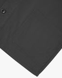 View of the mid-section and sleeve of the 3001 Uskees button-down drill overshirt in charcoal-grey with focus on hem and hip pocket.