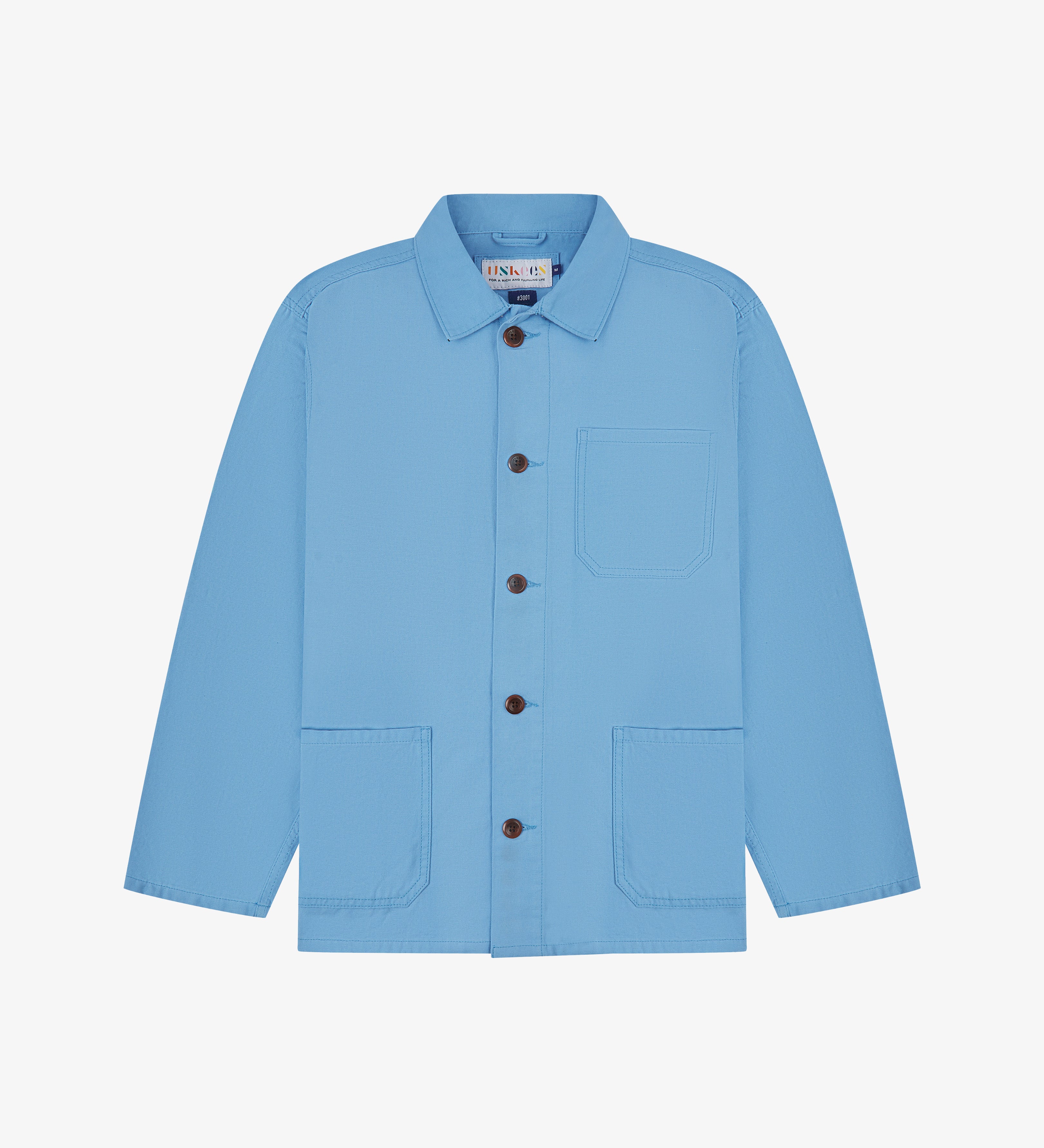Front, flat view of a light blue Uskees shirt jacket with brown buttons on a light gray background 