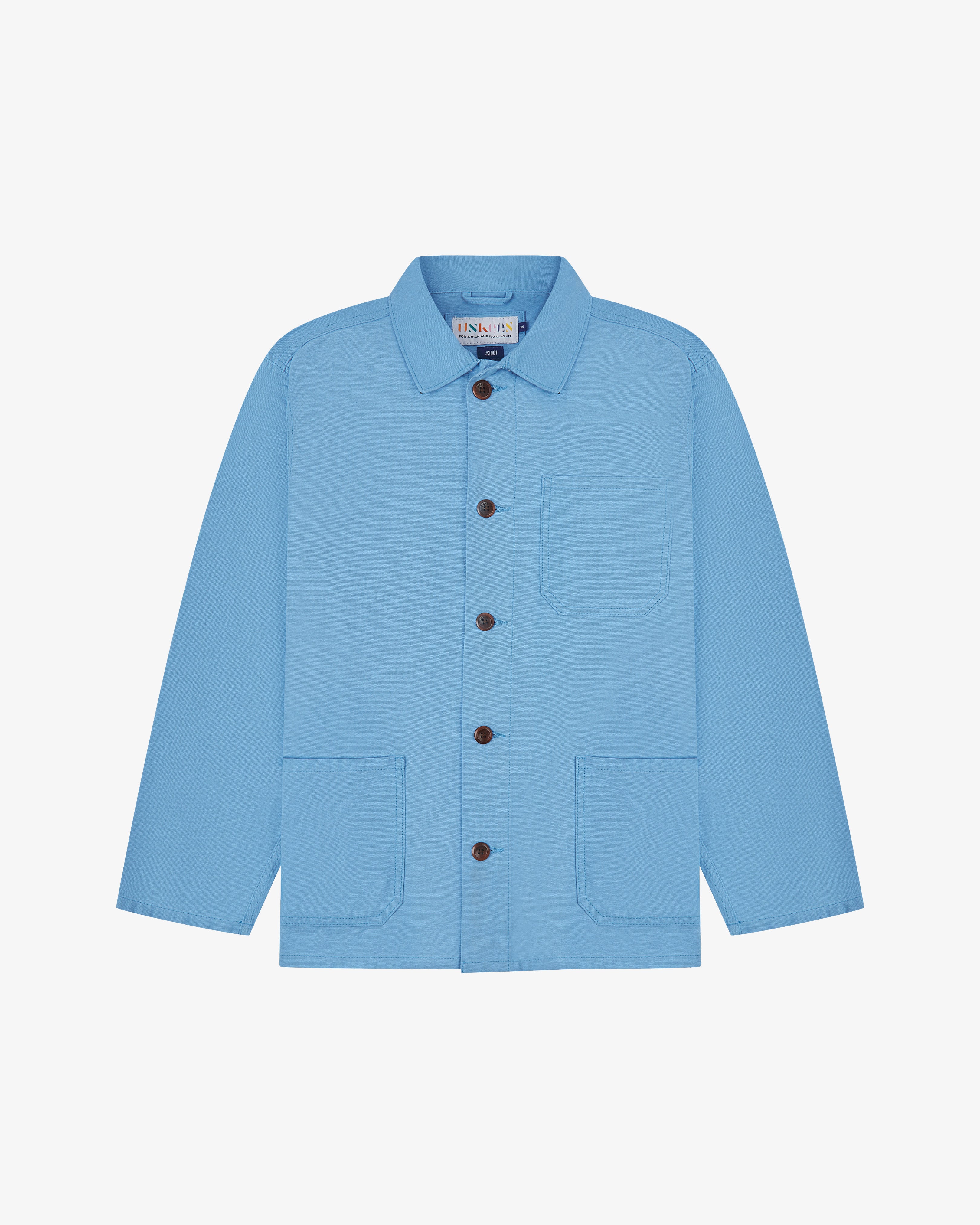 Front, flat view of a light blue Uskees shirt jacket with brown buttons on a light gray background 