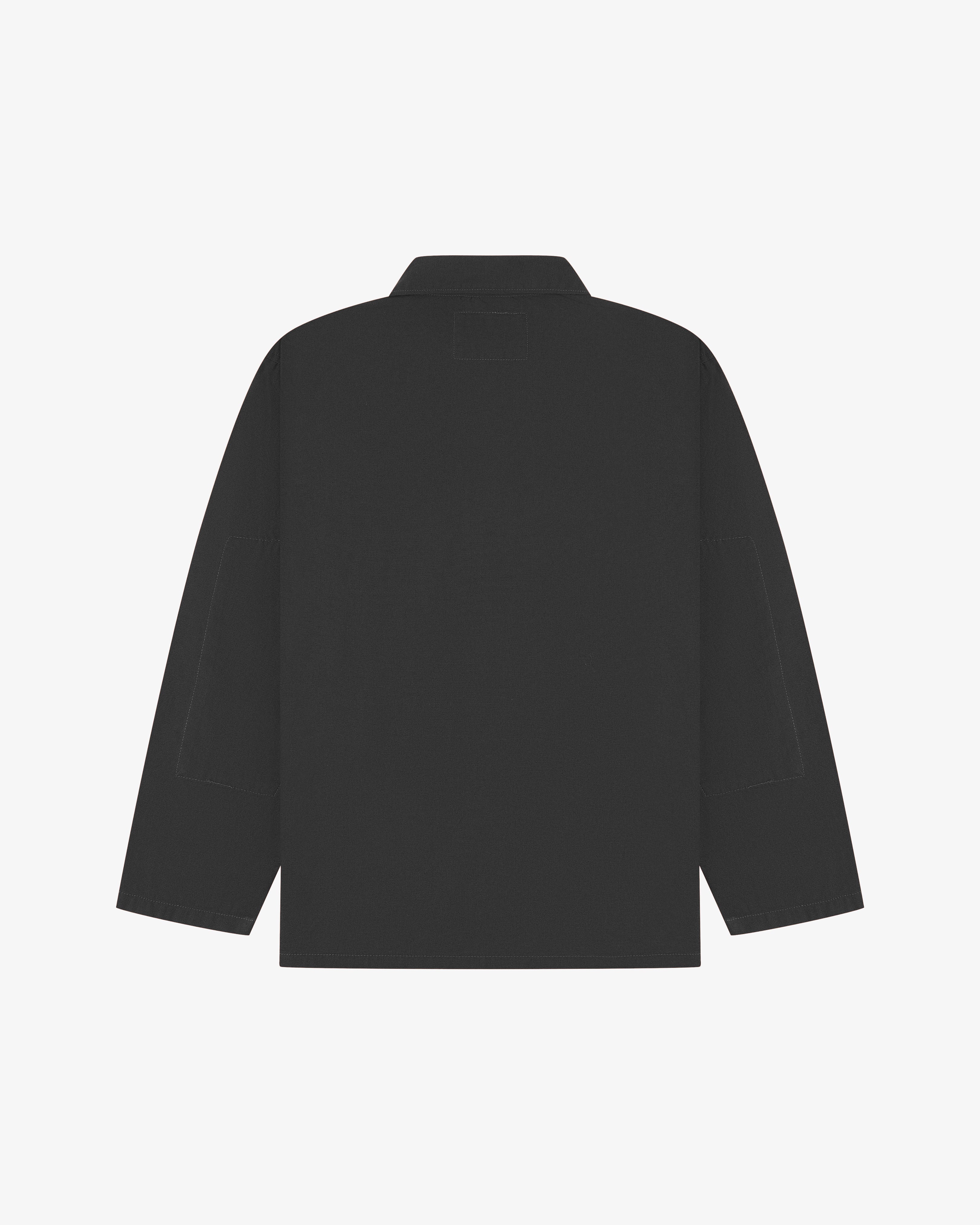 Back view of charcoal-grey, buttoned organic cotton overshirt with view of reinforced elbow area and boxy silhouette.