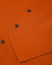 Front close shot of an uskees orange men's overshirt showing contrast brown corozo buttons and cuff/sleeve detail.