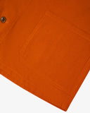 Closer view of mid section of golden-orange, buttoned organic cotton overshirt from Uskees. Focus on pockets and corozo buttons.