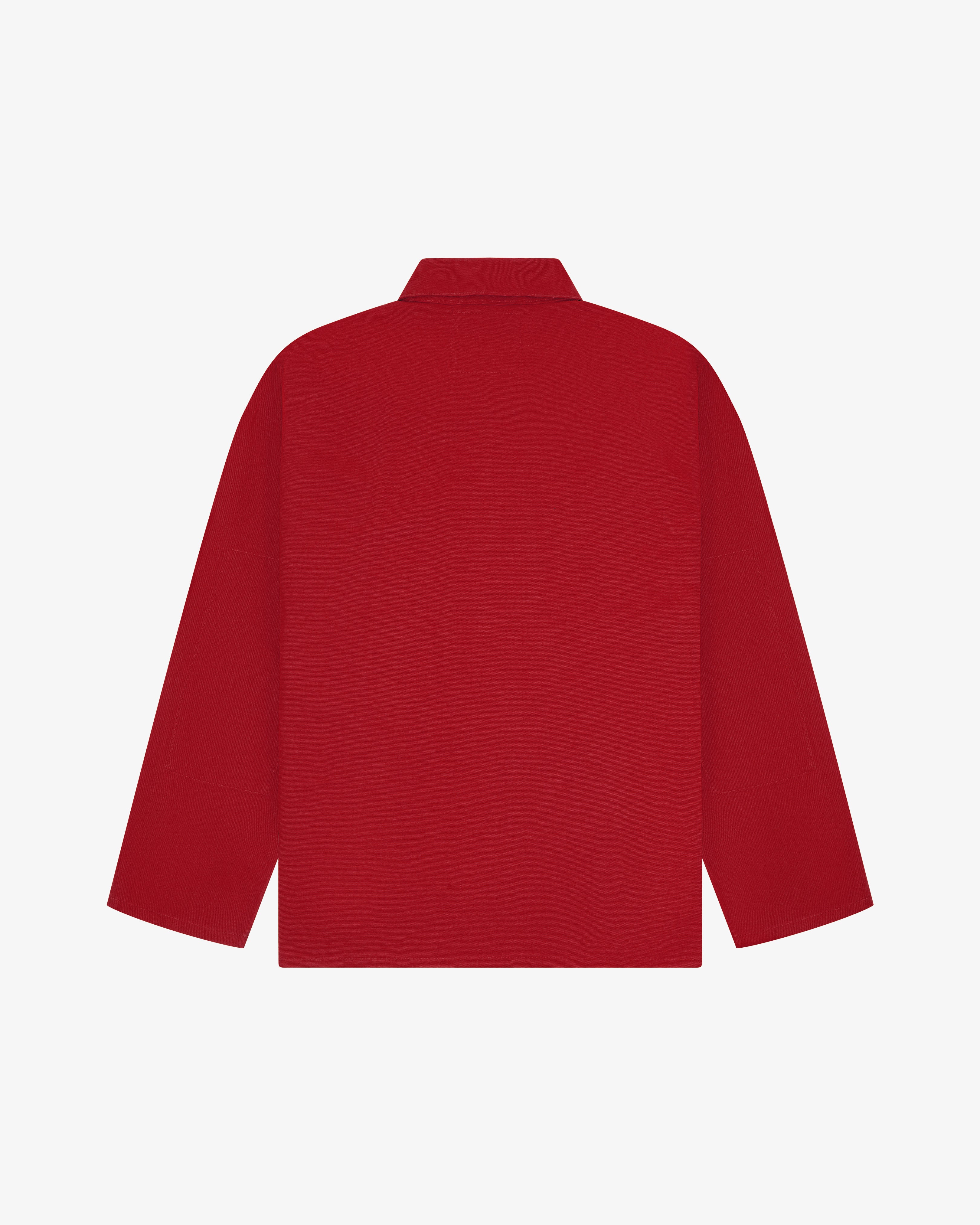 Back view of berry red, buttoned organic cotton overshirt with view of reinforced elbow area and boxy silhouette.