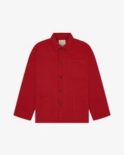 Front flat shot of berry red, buttoned organic cotton overshirt. Clear view of chest and hip pockets, corozo buttons and simple, boxy shape.