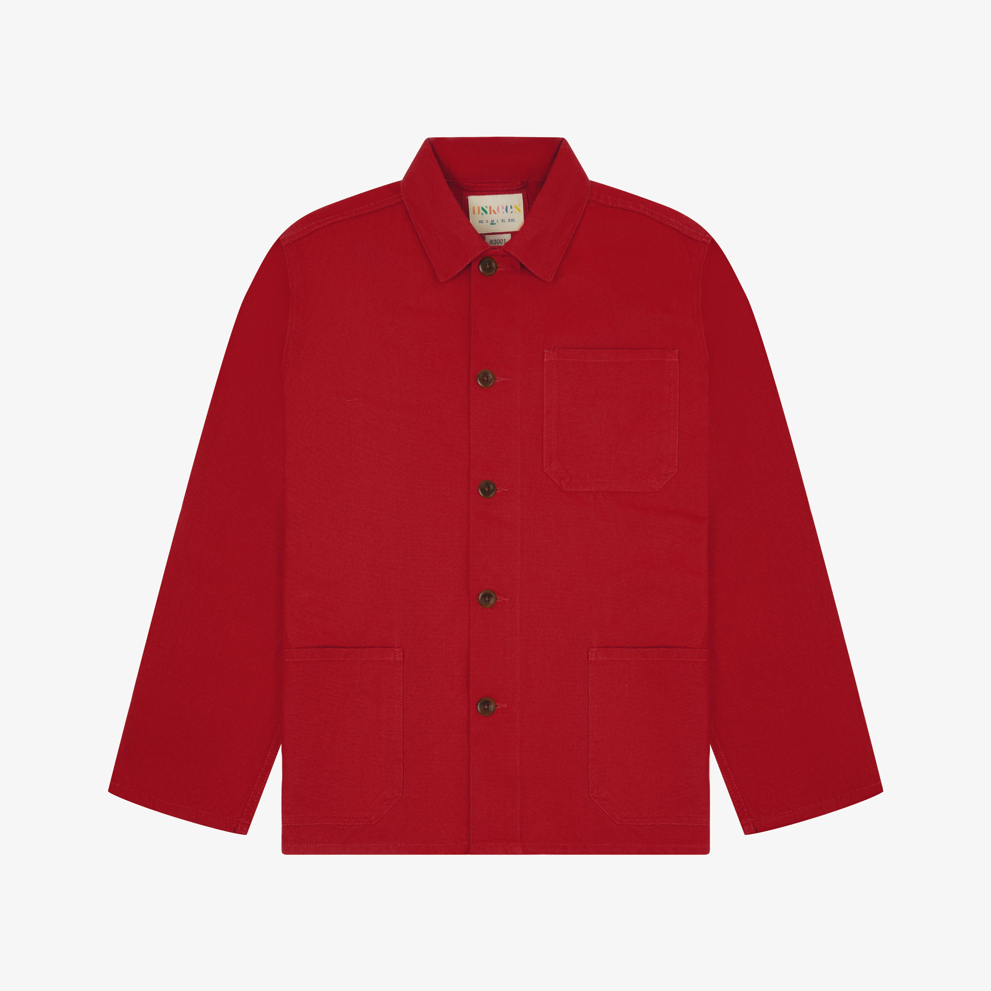 Front flat shot of berry red, buttoned organic cotton overshirt. Clear view of chest and hip pockets, corozo buttons and simple, boxy shape.