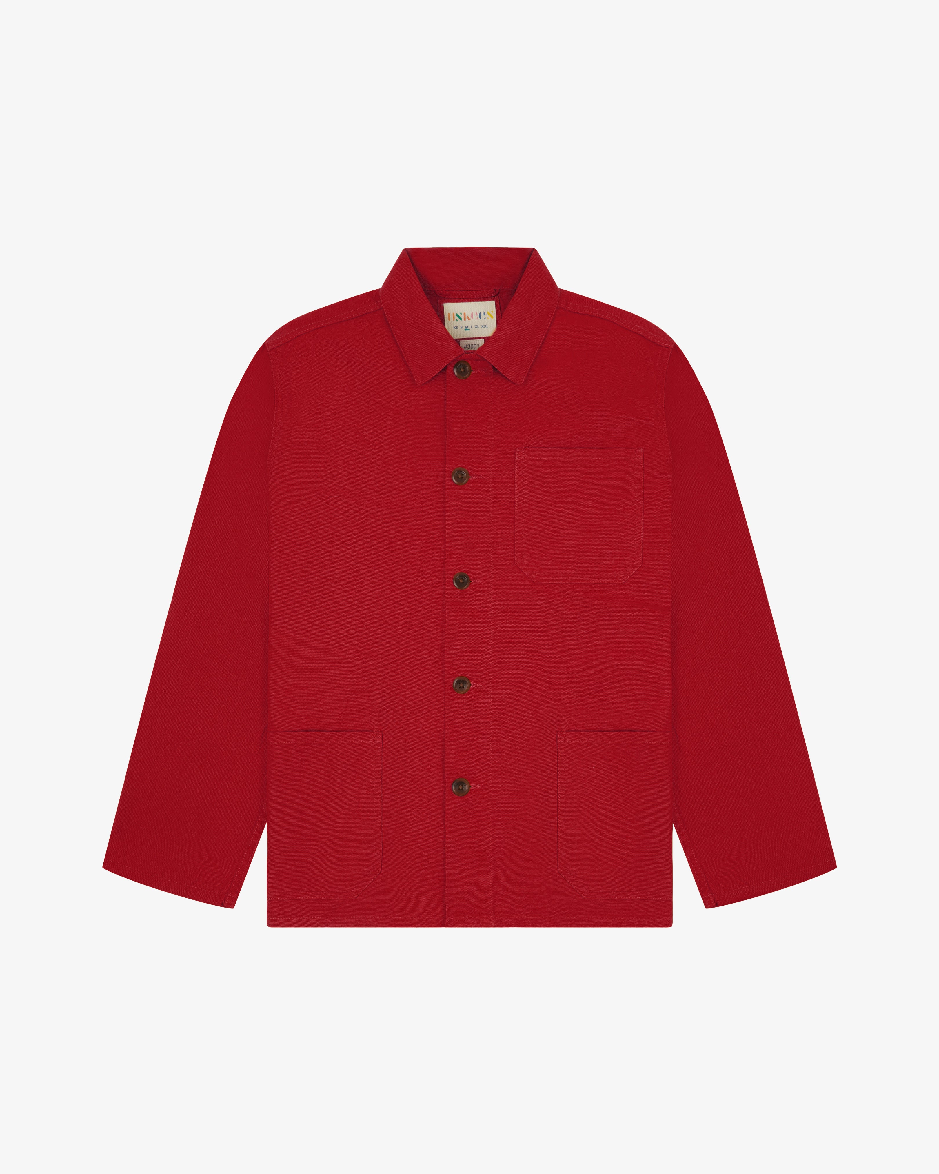 Front flat shot of berry red, buttoned organic cotton overshirt. Clear view of chest and hip pockets, corozo buttons and simple, boxy shape.