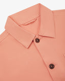 Close-up view of 3001 pink-orange (coral), buttoned organic cotton overshirt from Uskees showing corozo buttons, collar and hanging loop.