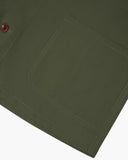 Closer view of mid section of coriander-green, buttoned organic cotton overshirt from Uskees. Focus on hem, pockets and corozo buttons.