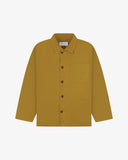 Front flat shot of Uskees organic cotton mustard yellow shirt-jacket with clear view of the Corozo buttons, presented on a light gray background