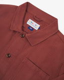 Front close-up flat view of Uskees Chestnut Brown drill shirt jacket showing Corozo button details and brand label at neck on a white background