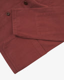 Close-up flat view of Uskees Chestnut Brown men's drill shirt jacket showing Corozo button, pocket and cuff details on a white background.