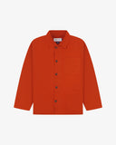 Front flat view of deep orange shirt-jacket showing the collar, Uskees brand label and 3 front pockets on a white background