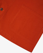 Close-up of a rust-orange pocket on an uskees 3001 overshirt with a white background