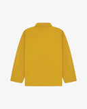 Back view of yellow, buttoned organic cotton overshirt with view of reinforced elbow area and boxy silhouette.