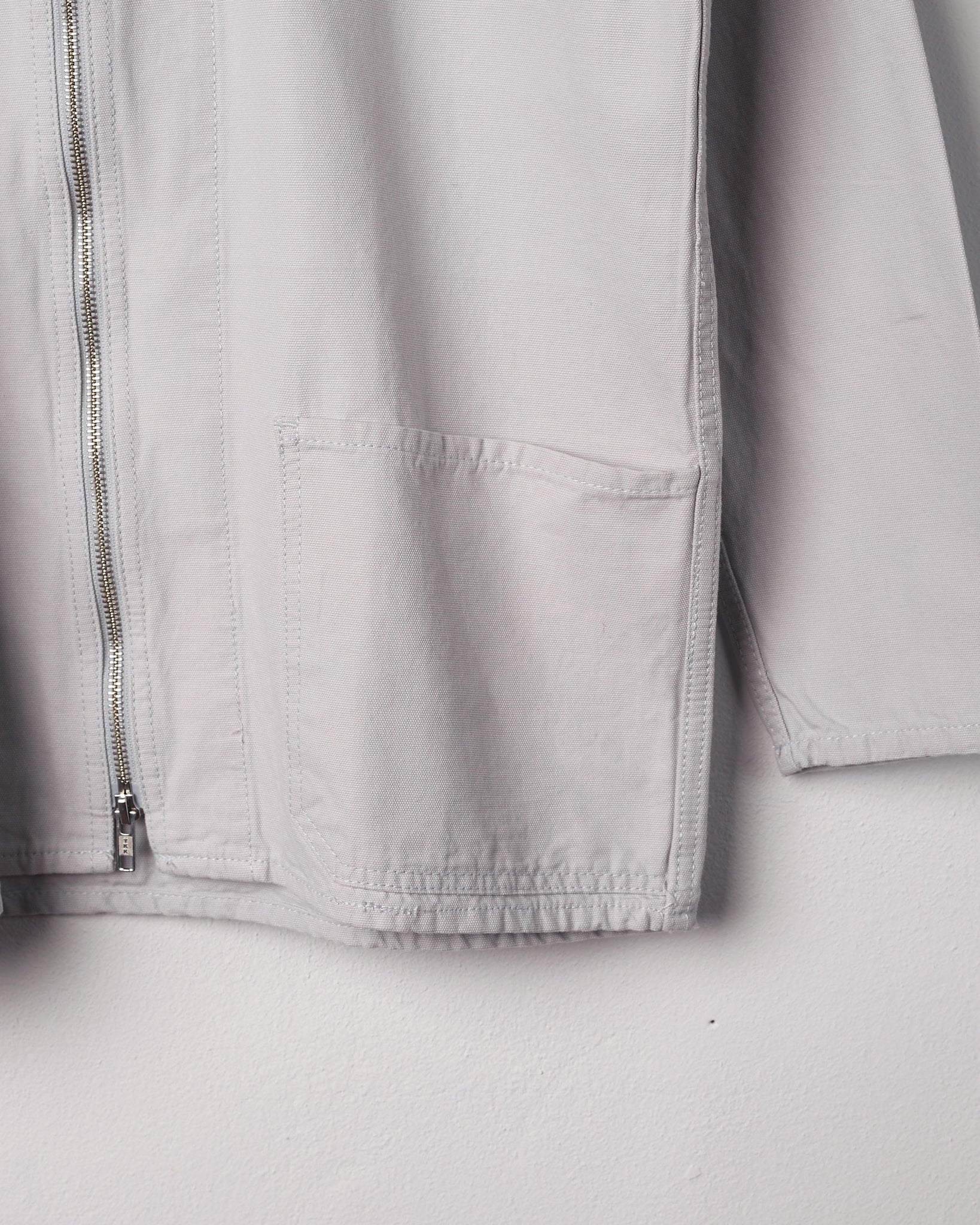 Close-up of organic cotton, #3002 light-grey zip jacket focussing on the hip pocket.
