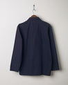 Back view of the #3002 midnight blue zip jacket displayed on a hanger, showing reinforced elbows and simple silhouette.