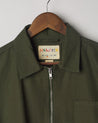 Close-up view of the collar of the Uskees #3002, vine green zip-front jacket. Zipped up to demonstrate collar shape and boxy jacket silhouette.