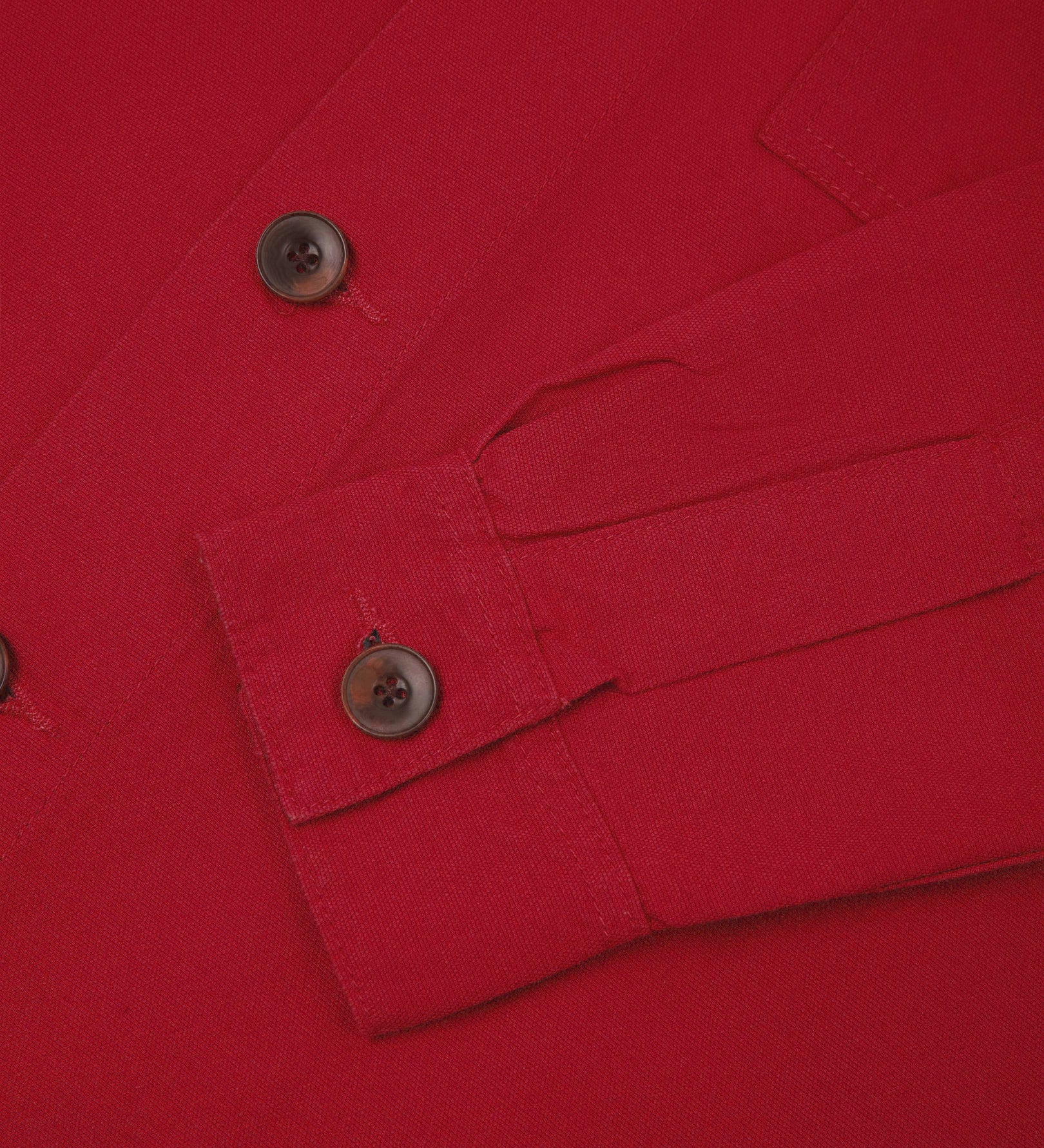 View of the mid-section and sleeve of the 3003 Uskees button-down work shirt in berry red with focus on cuff, placket and corozo buttons.