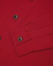 View of the mid-section and sleeve of the 3003 Uskees button-down work shirt in berry red with focus on cuff, placket and corozo buttons.