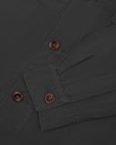 View of the mid-section and sleeve of the 3003 Uskees button-down work shirt in charcoal with focus on cuff, placket and corozo buttons.