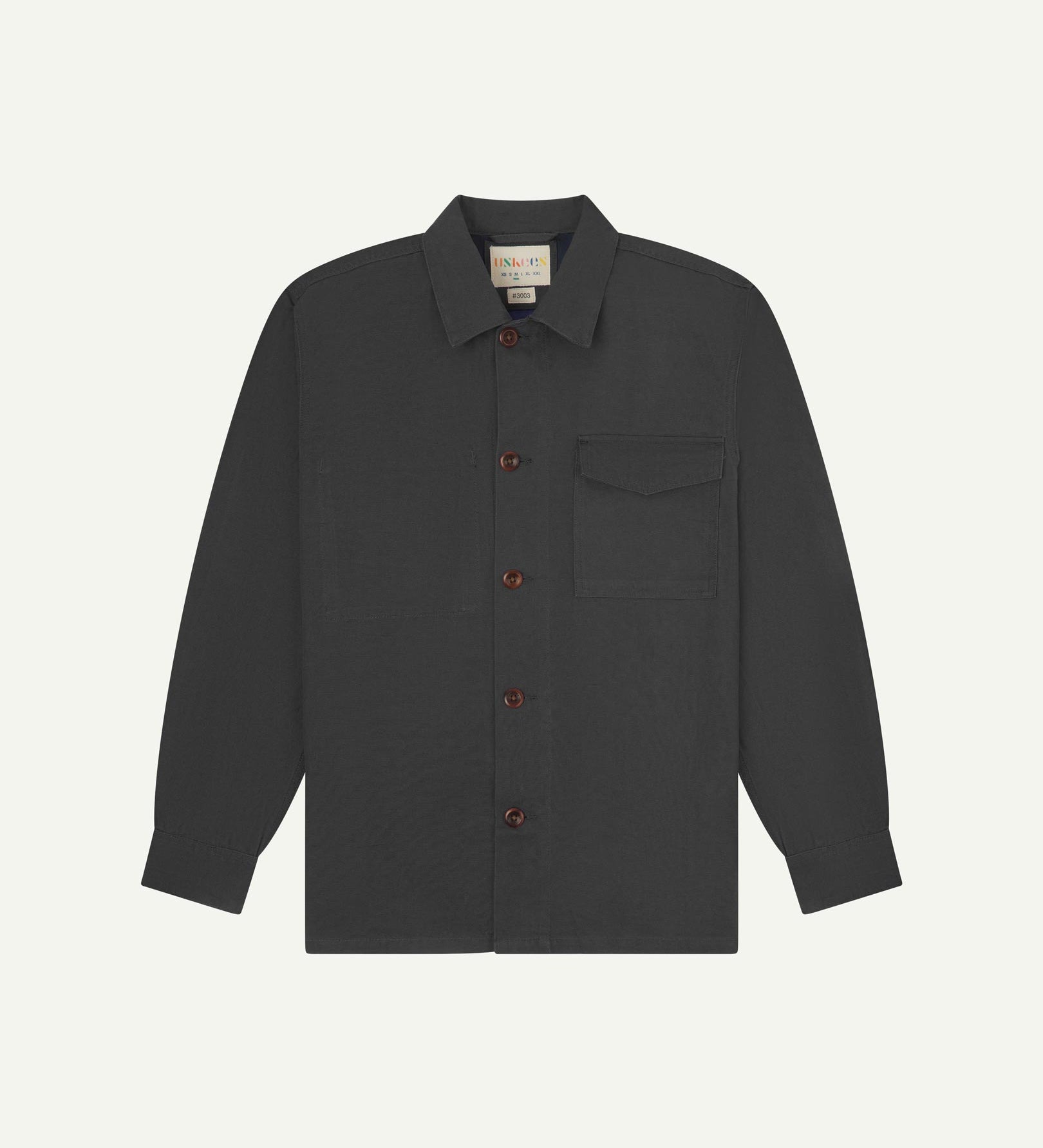 Charcoal buttoned organic cotton overshirt from Uskees with clear view of chest pocket and Uskees branding label.