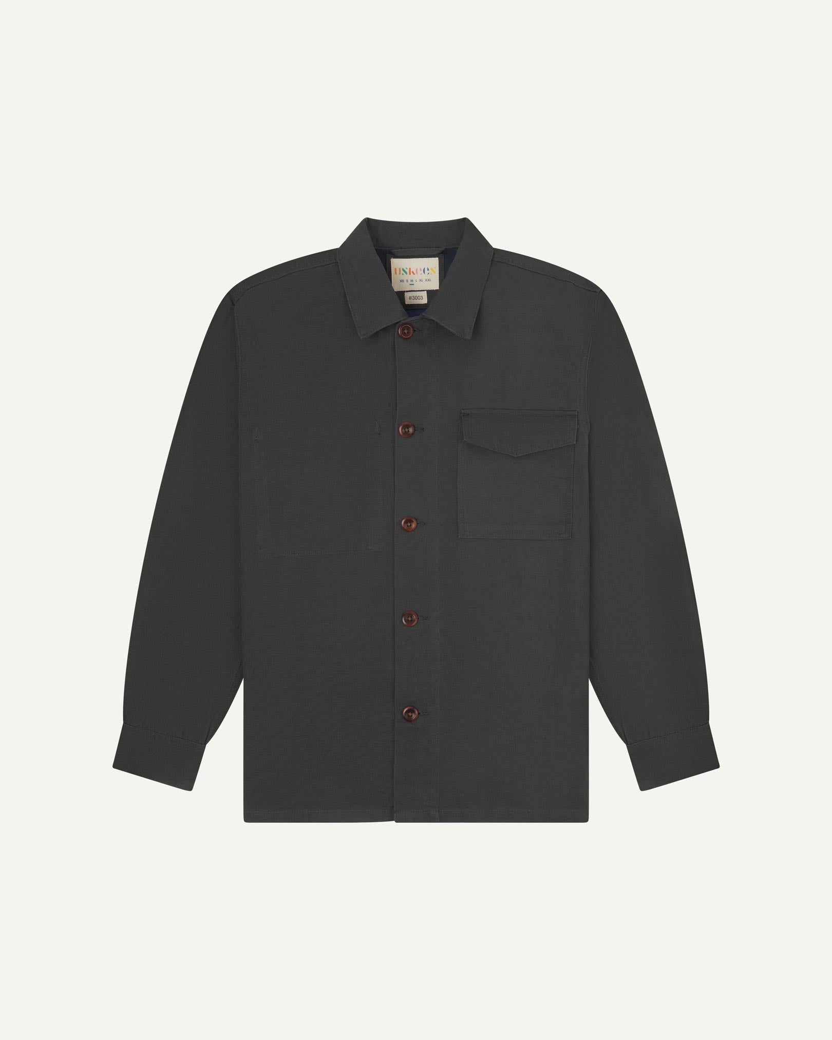 Charcoal buttoned organic cotton overshirt from Uskees with clear view of chest pocket and Uskees branding label.