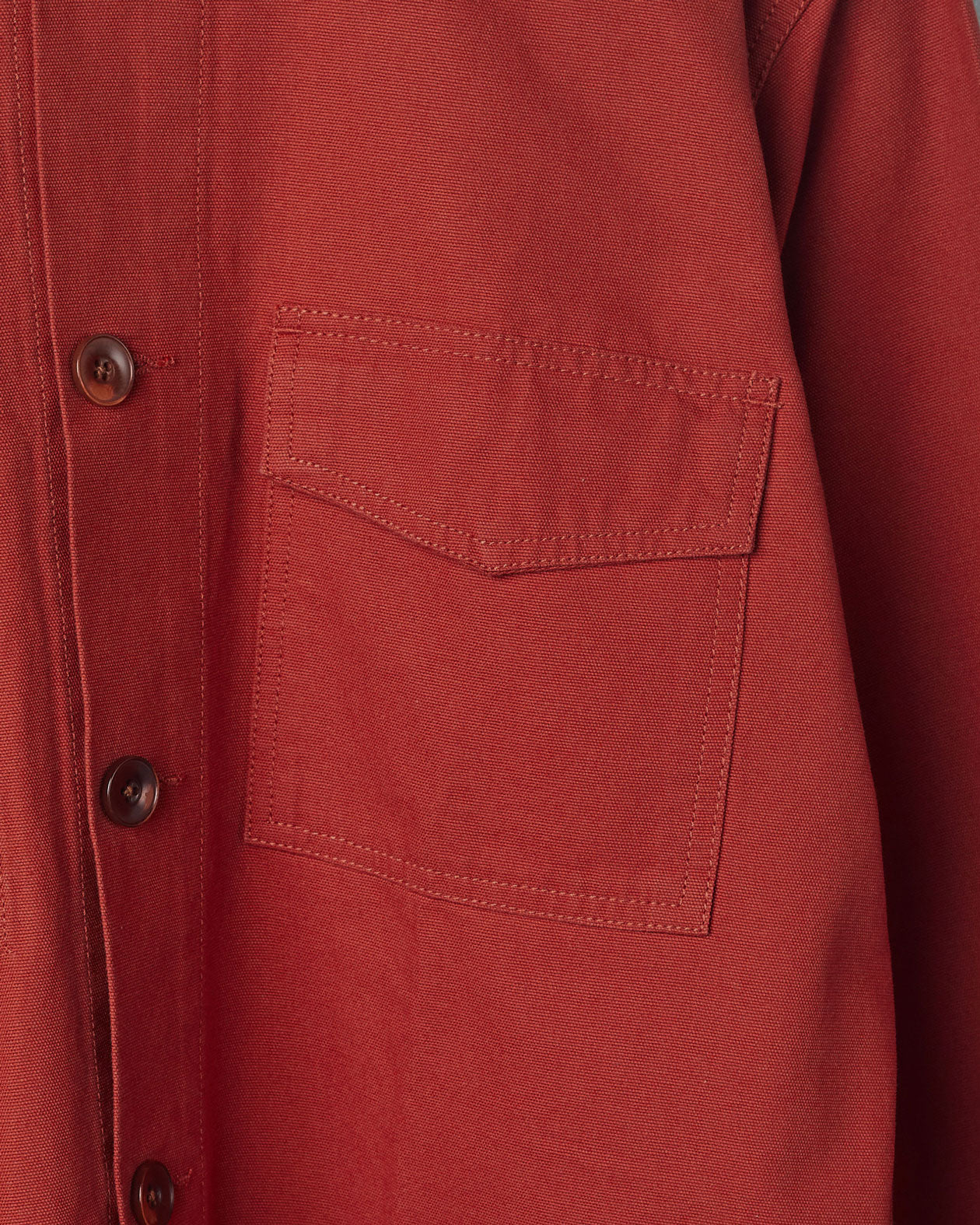 Mid-right view of #3003 Uskees buttoned workshirt in 'clay-red' with focus on breast pocket and corozo buttons.