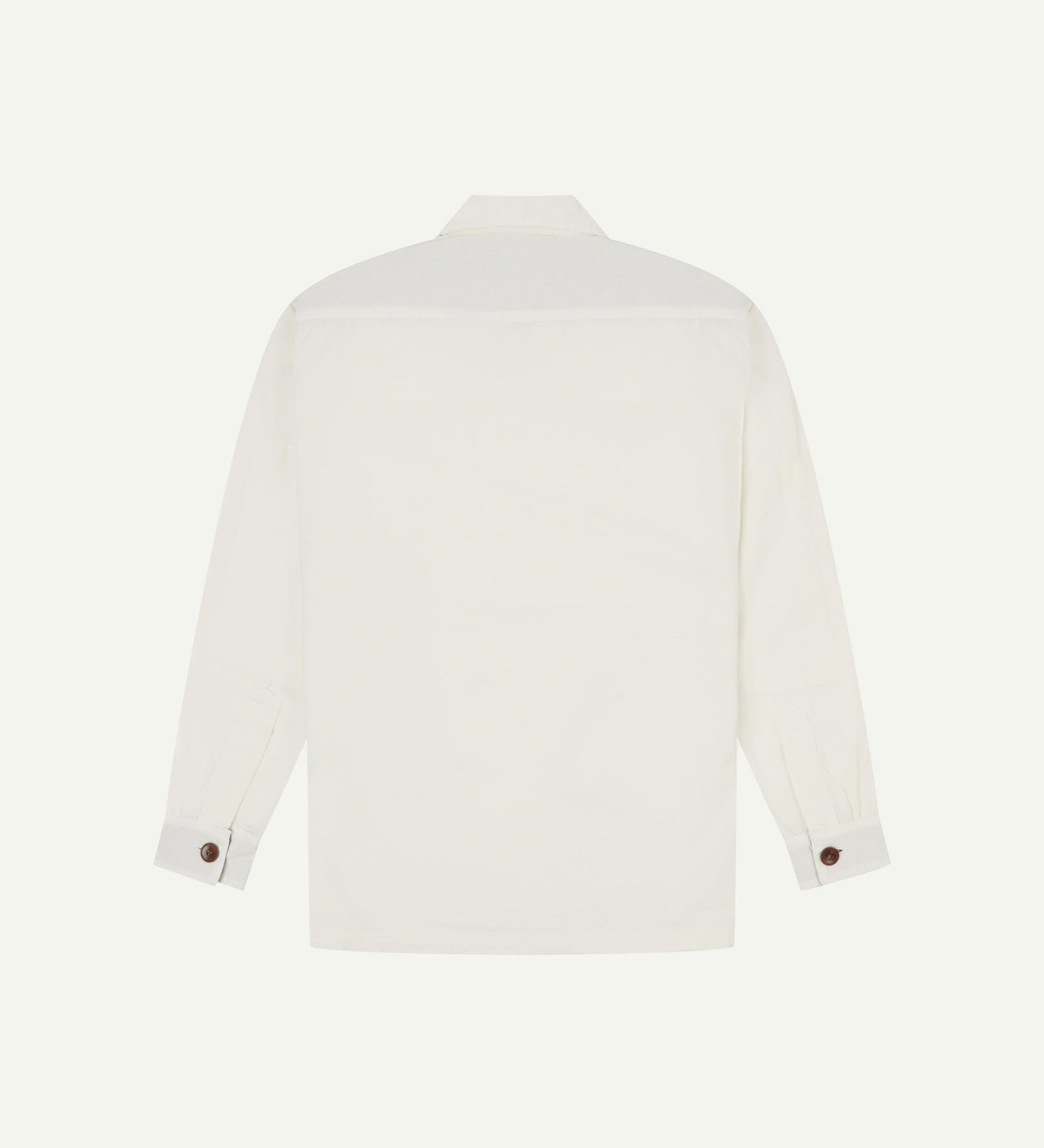 Reverse of cream buttoned organic cotton workshirt from Uskees showing reinforced elbows, tailored cuffs and boxy silhouette.
