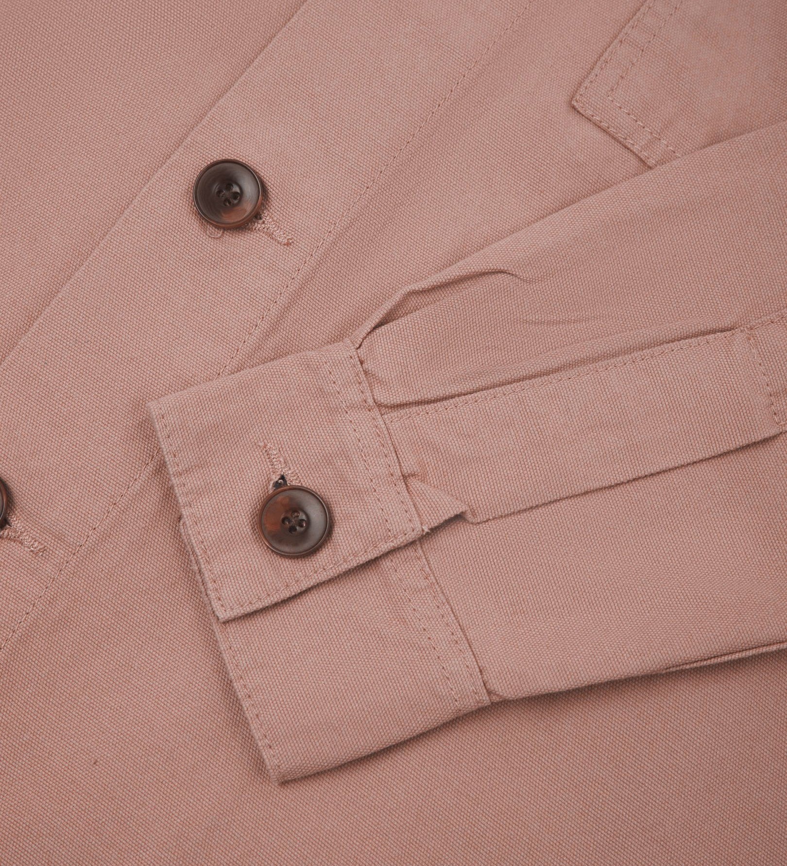 View of the mid-section and sleeve of the 3003 Uskees button-down work shirt in dusty pink with focus on cuff, placket and corozo buttons.