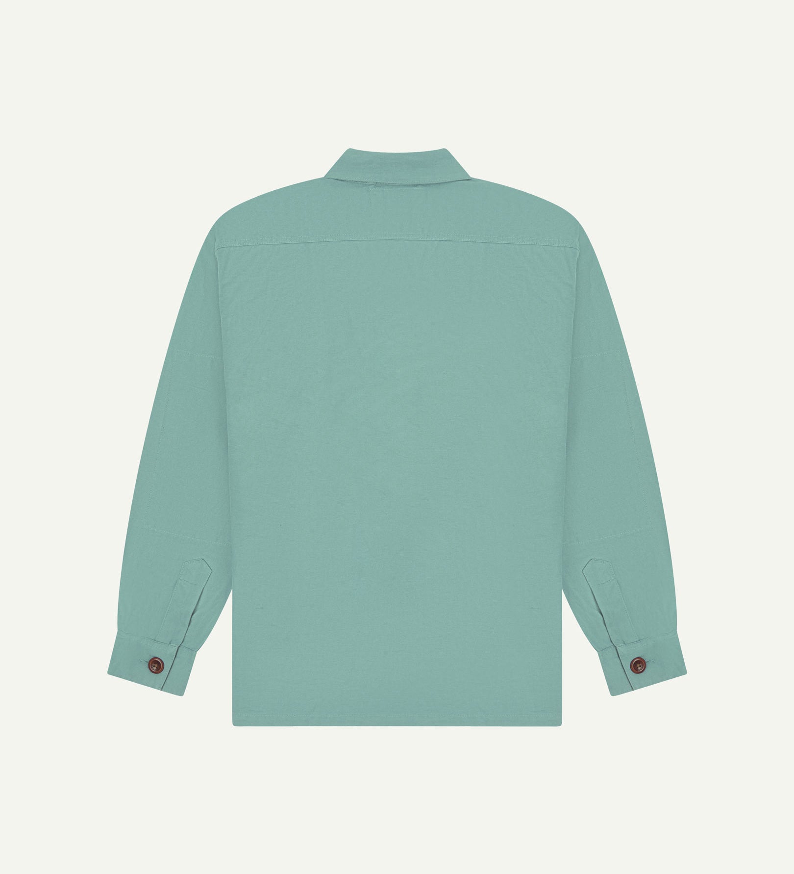 Reverse of eucalyptus (mint-green) buttoned organic cotton workshirt from Uskees showing reinforced elbows, tailored cuffs and boxy silhouette.