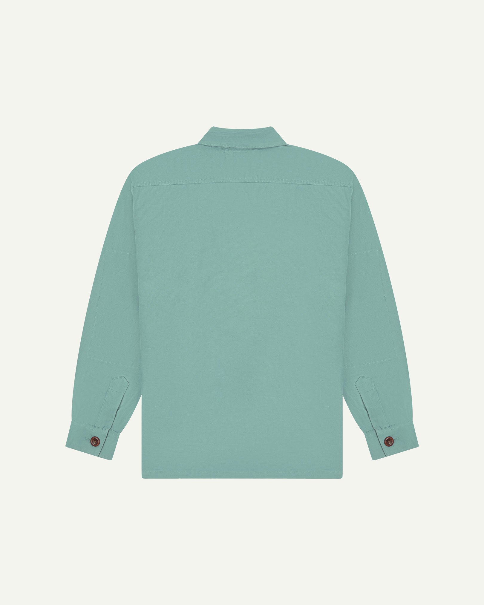 Reverse of eucalyptus (mint-green) buttoned organic cotton workshirt from Uskees showing reinforced elbows, tailored cuffs and boxy silhouette.