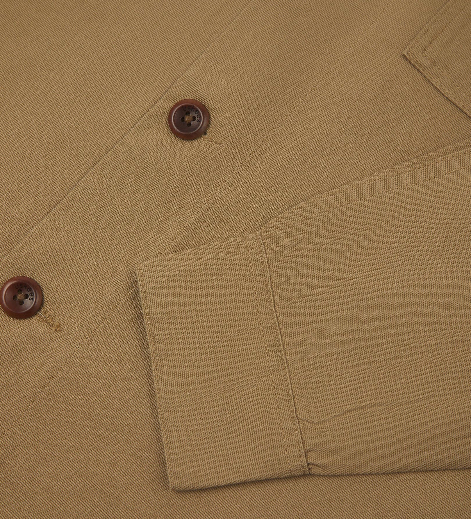 View of the mid-section and sleeve of the 3003 Uskees button-down work shirt in khaki with focus on cuff, placket and corozo buttons.