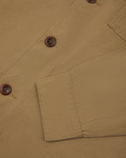 View of the mid-section and sleeve of the 3003 Uskees button-down work shirt in khaki with focus on cuff, placket and corozo buttons.