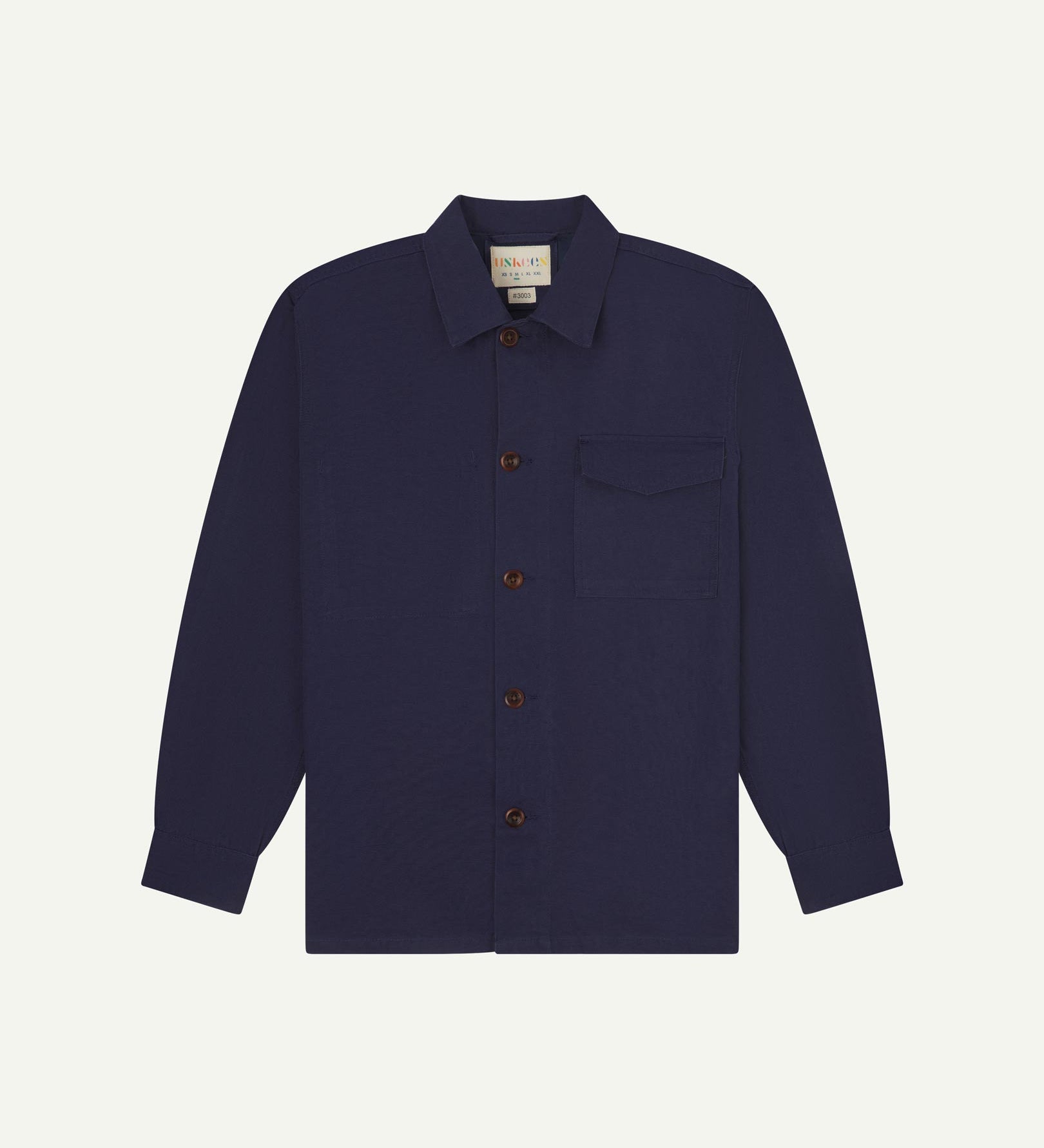 Midnight blue buttoned organic cotton workshirt from Uskees with clear view of chest pocket and Uskees branding label.